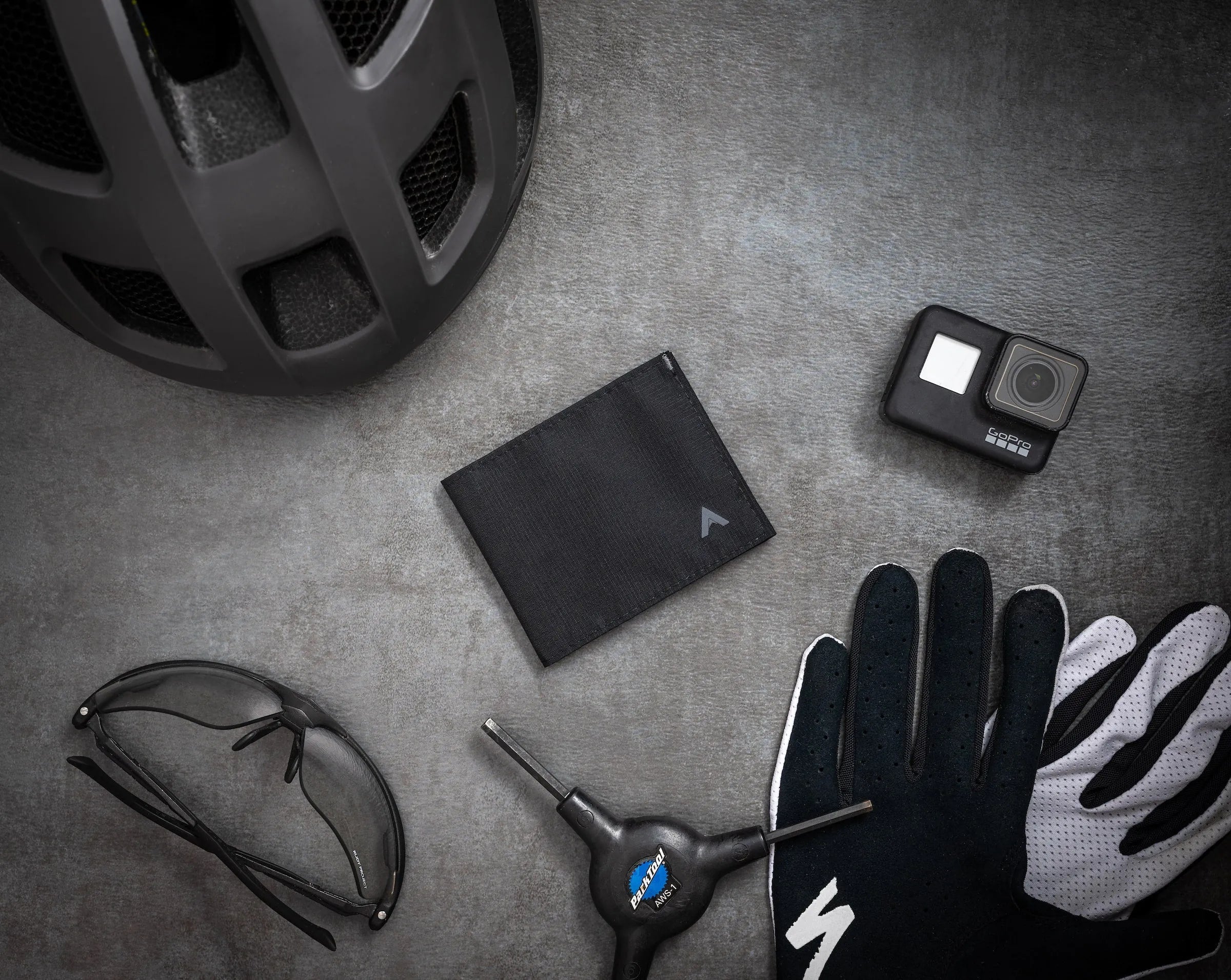 Image shows a black nylon wallet on a table. The wallet is made with "ripstop nylon" that resists tears. It is also breathable, which makes it a popular sports wallet.