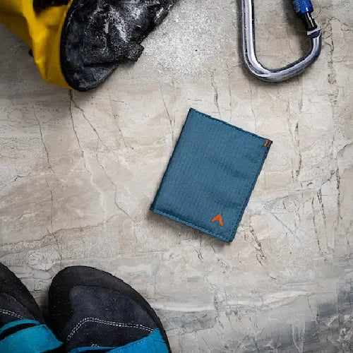 Image is of a blue vegan nylon wallet from Allett Wallets lying on a table. Made with ripstop nylon that is breathable and lightweight.