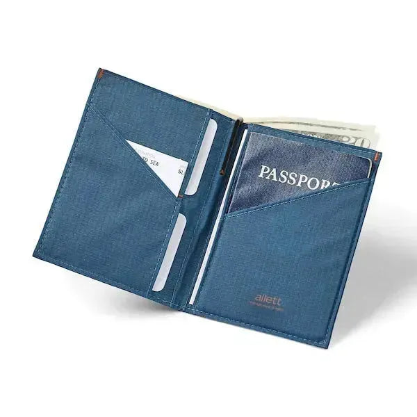 Open passport travel wallet made in indigo blue nylon, showing the passport on the right side, cards on the left, and a micropen sticking out of a dedicated pocket in the center fold. Allett Travel Wallet RFID Nylon - indigo-blue