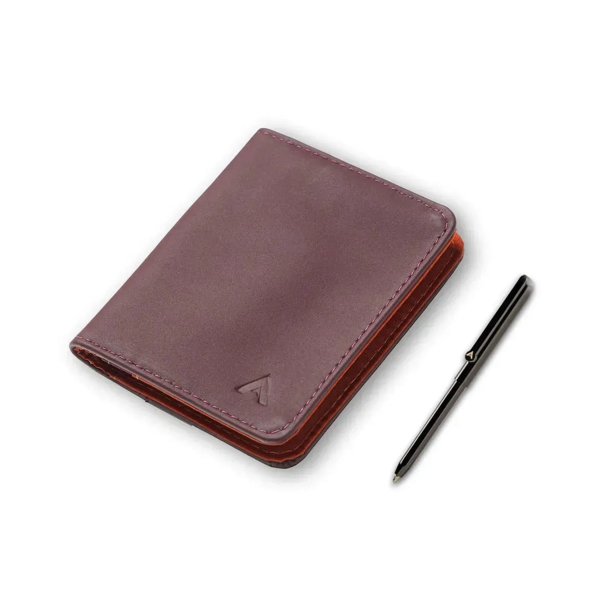 Shut merlot leather card wallet from Allett next to a silver finish micro pen that fits in the wallet. Allett Leather Hybrid Card Wallet merlot pen