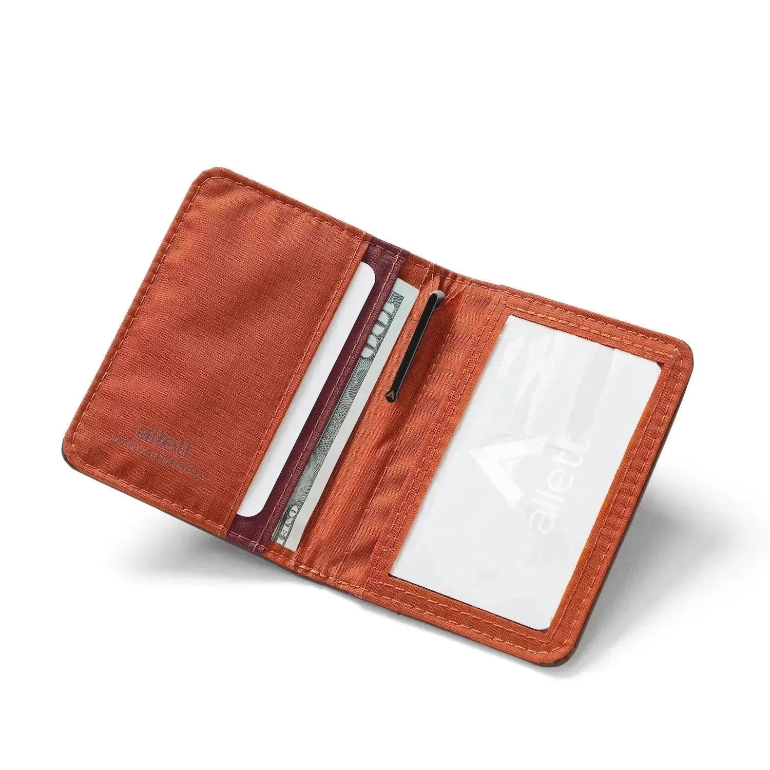 Displayed vibrant orange material of the hybrid merlot leather card wallet that shows the ID window on the right side and the card pockets on the left side. Allett hybrid card wallet leather merlo
