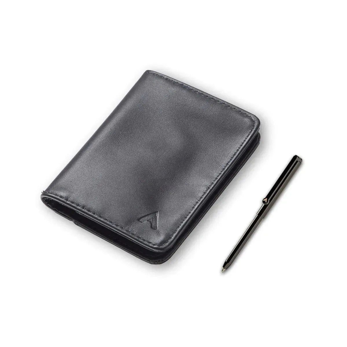 Tightly closed onyx black Nappa leather RFID card wallet against a white background next to a small silver micro pen. Allett hybrid card wallet leather onyx-black pen