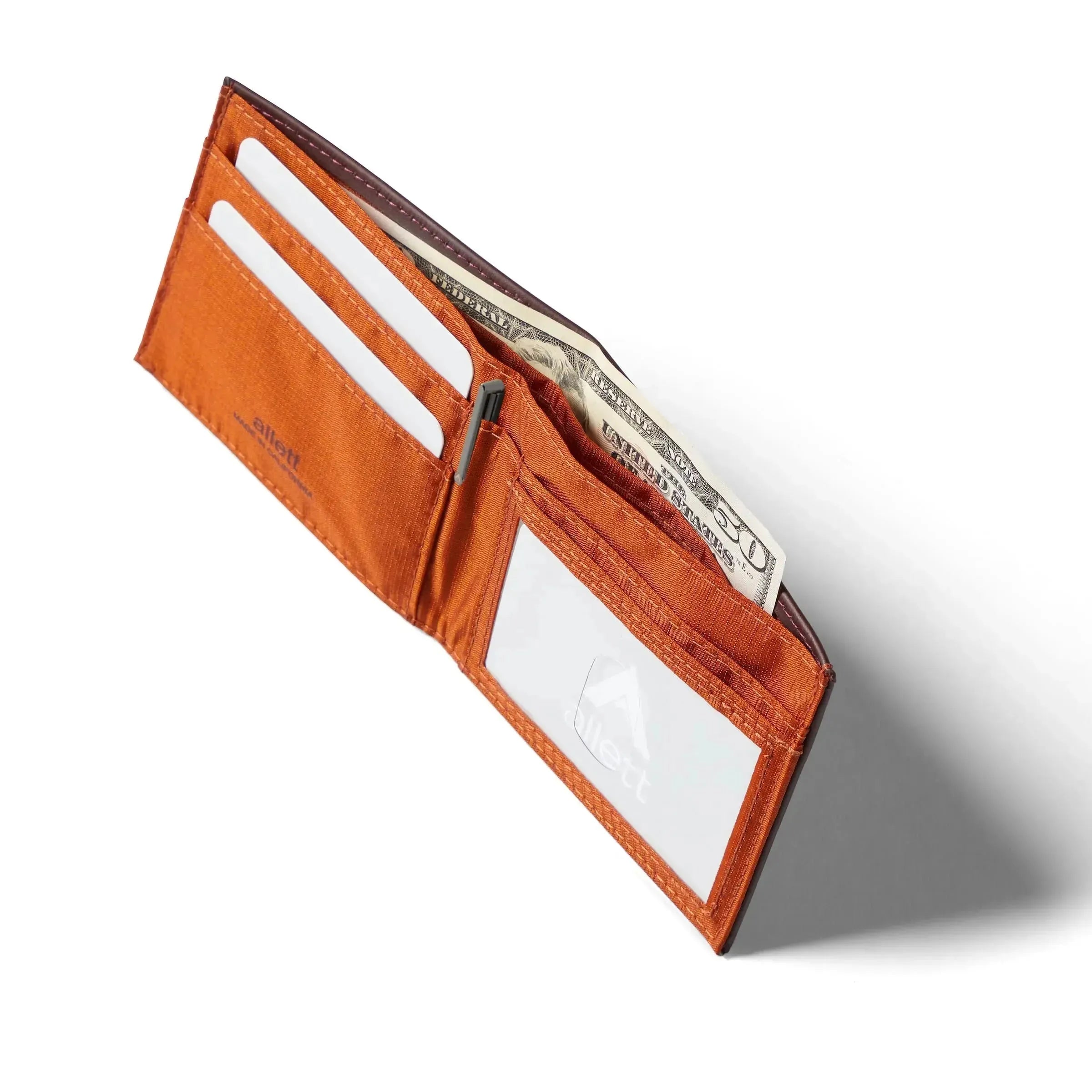 Open merlot color leather wallet with an orange nylon interior and an open space for an ID. Allett id wallet leather merlot
