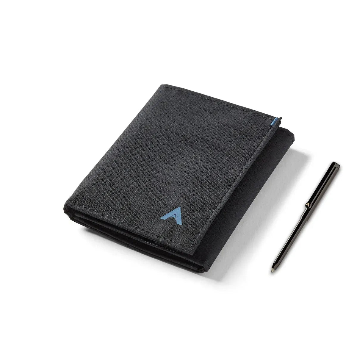 Jet black trifold wallet in vegan ripstop nylon sitting closed against a white background next to a silver micropen. Allett Trifold Wallet nylon edition - jet-black - pen