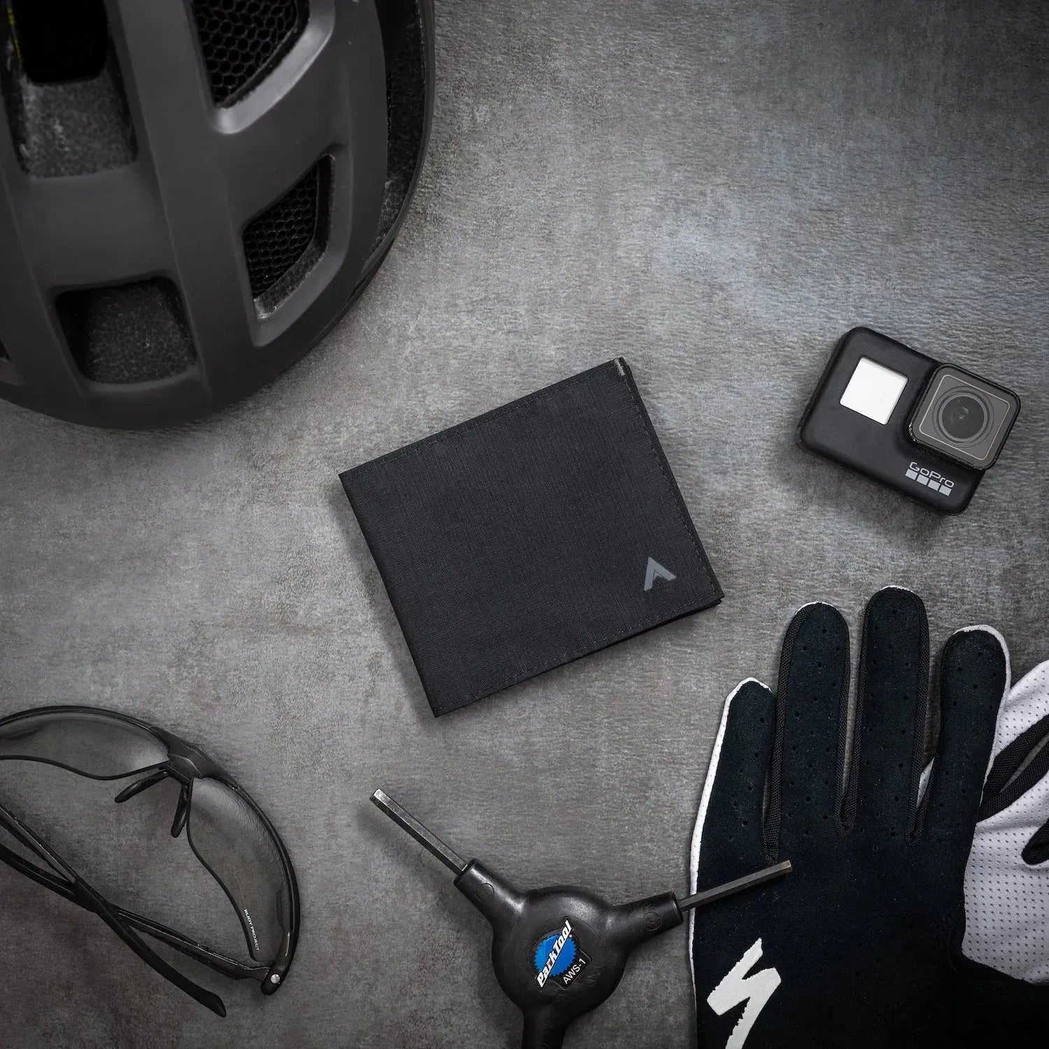 Jet black nylon ID wallet with RFID blocking fabric on a noir table surrounded by black glasses and black outdoor gear -Allett ID Wallet Nylon RFID jet-black