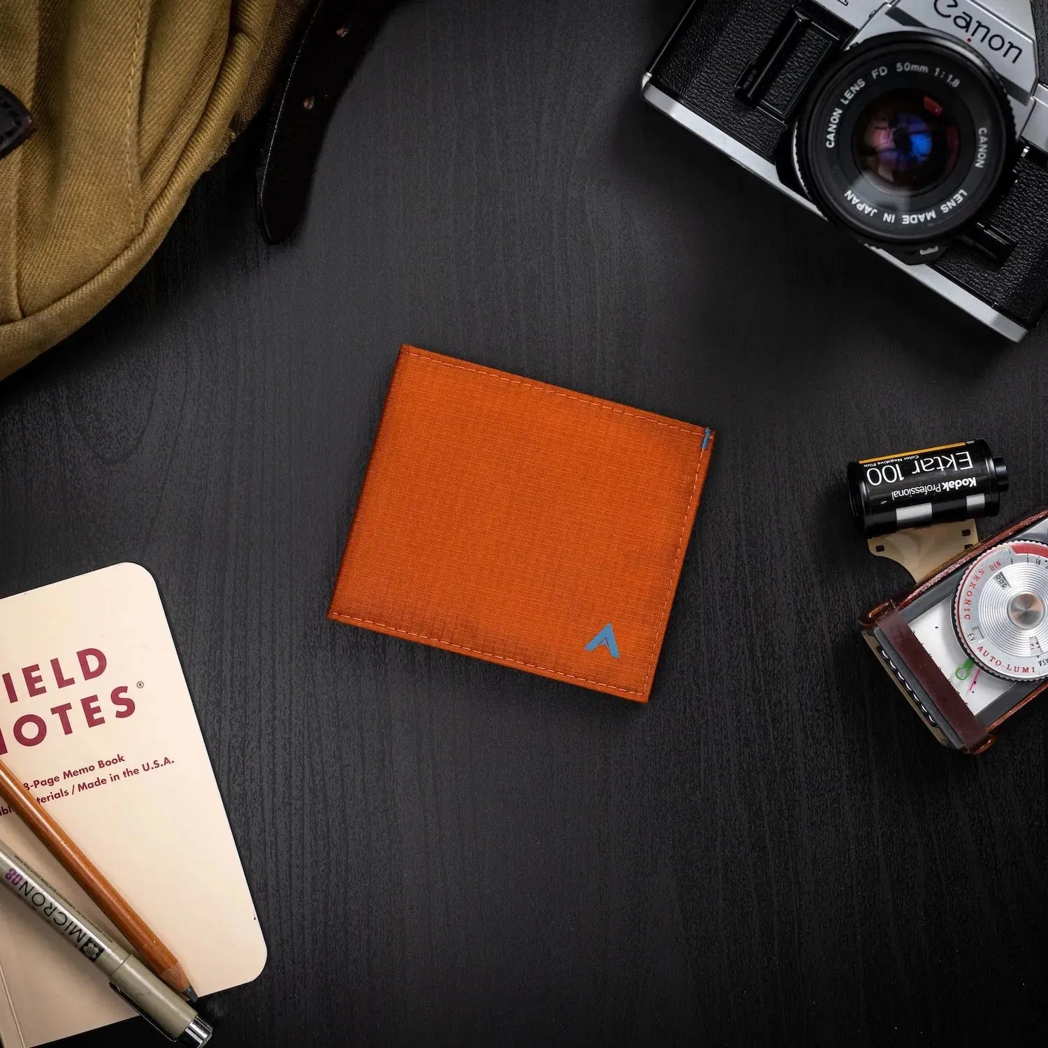 Beautiful potters clay nylon ID wallet on a black table surrounded by photography tools and other items -Allett ID Wallet Nylon RFID potters-clay
