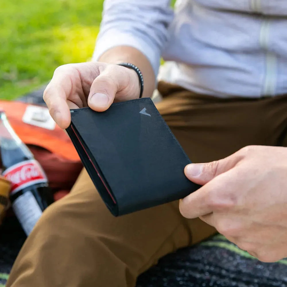 Unspecified person outdoors holding a black vegan ID wallet - Allett ID Wallet Nylon RFID jet-black