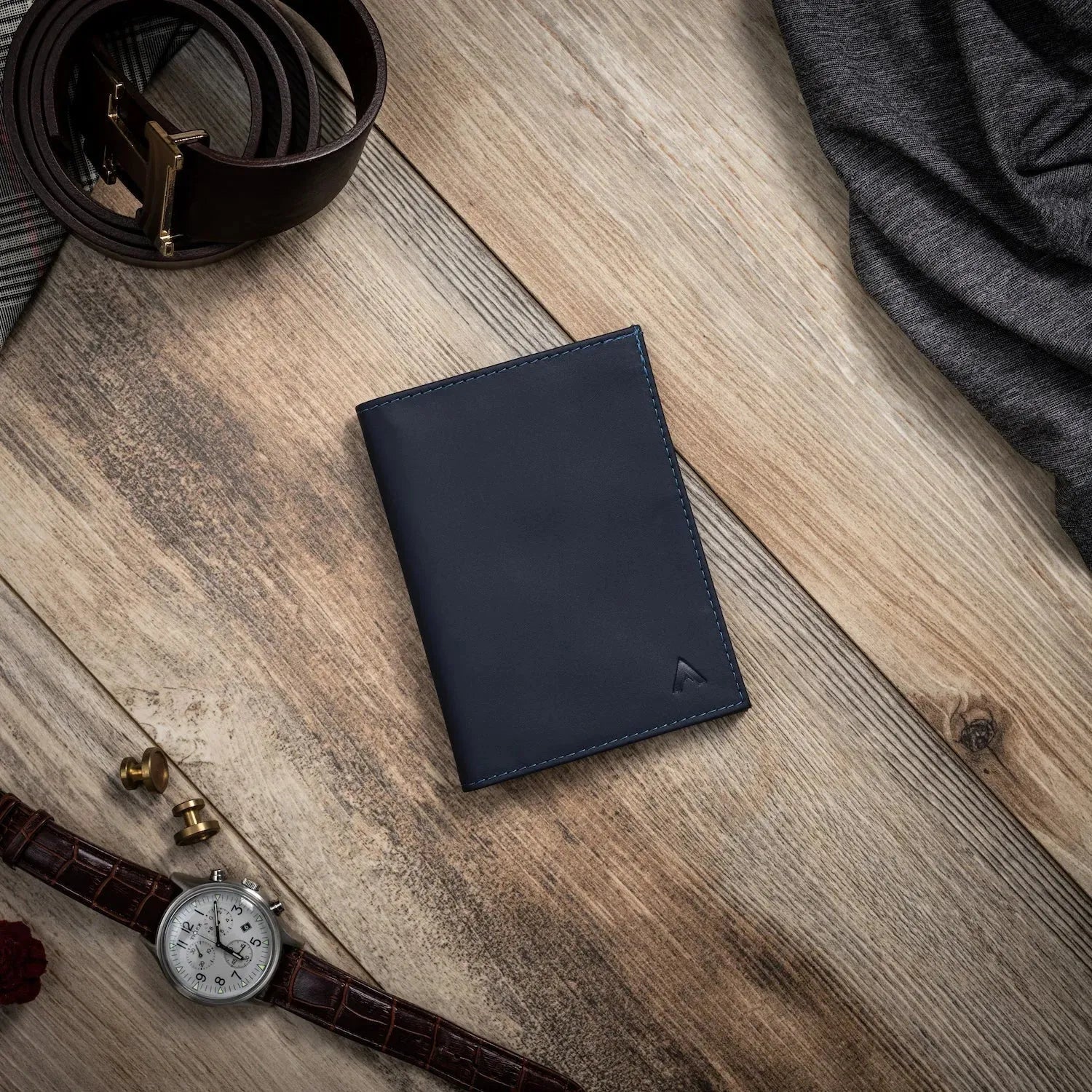 Dark leather wallet aganst a wood table. Allett leather original wallet midnight-blue