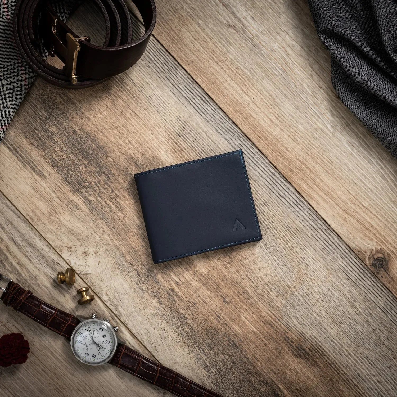 The Nappa leather sports wallet in midnight blue, laid flat on a wood surface. Allett leather sport wallet midnight-blue