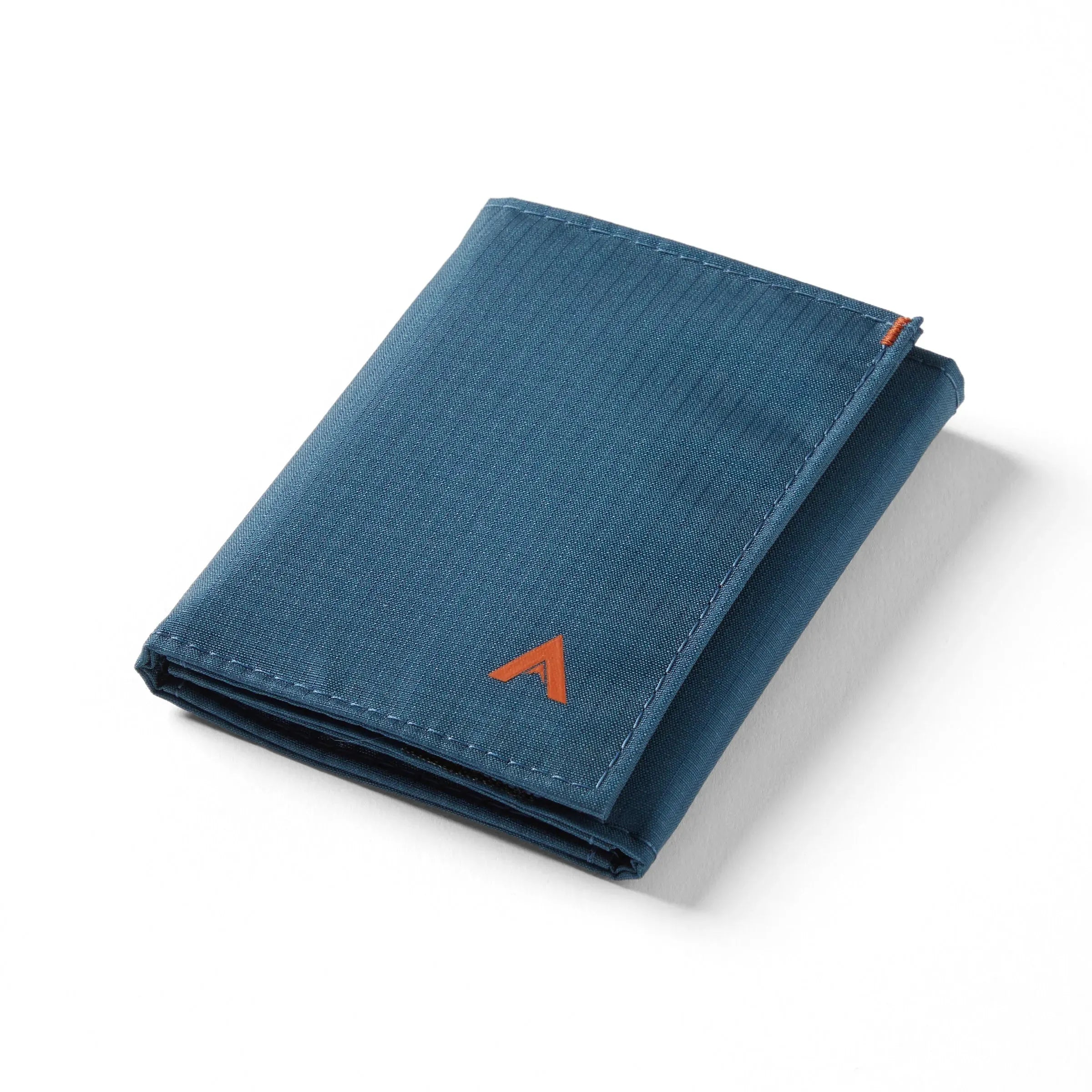 Indigo blue vegan nylon trifold wallet, closed, poised against a white backdrop. Allett Trifold Wallet nylon edition - indigo-blue