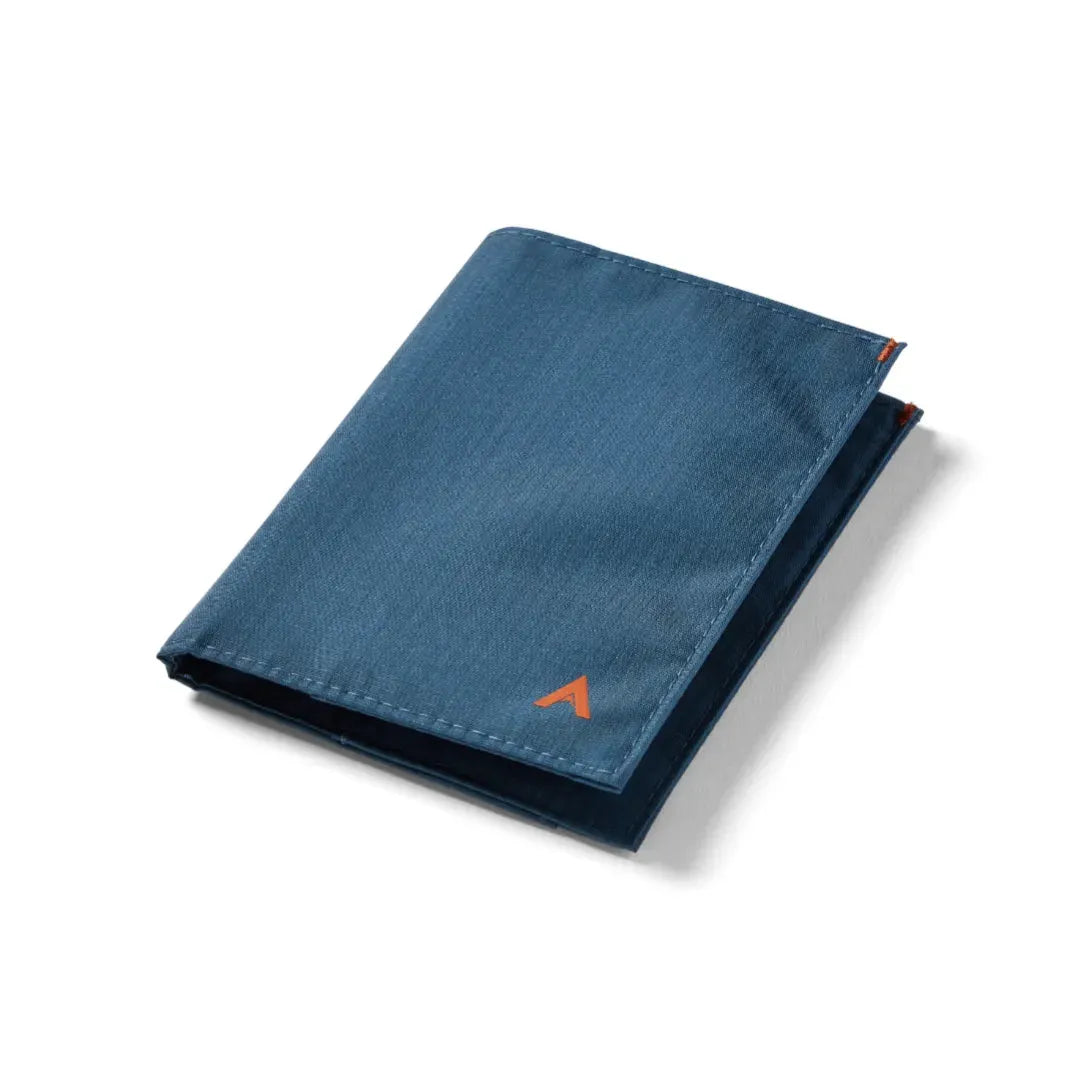 Closed indigo blue allett coin wallet placed down on a white background. allett coin wallet indigo-blue