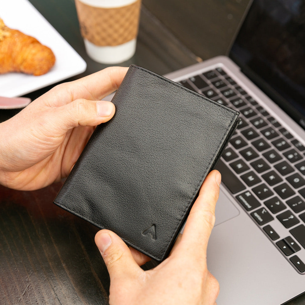 Two hands holding a black leather "original" style wallet from Allett. Allett leather original wallet onyx-black