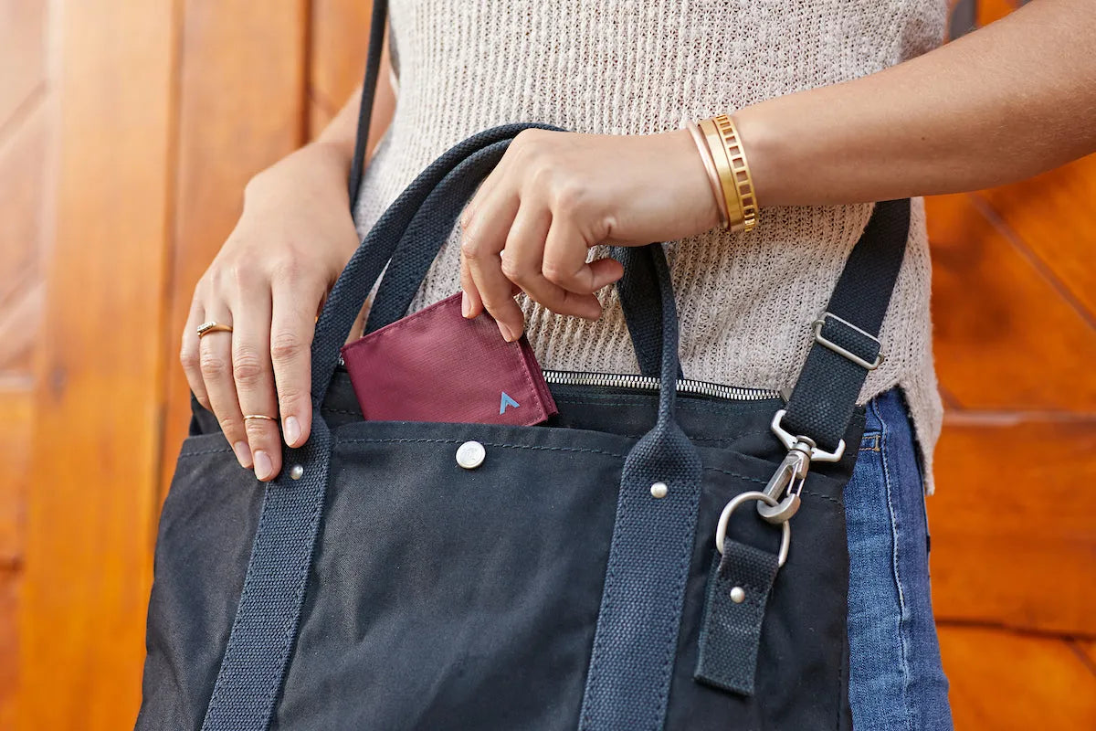Woman putting an Allett Wallet in her pocket