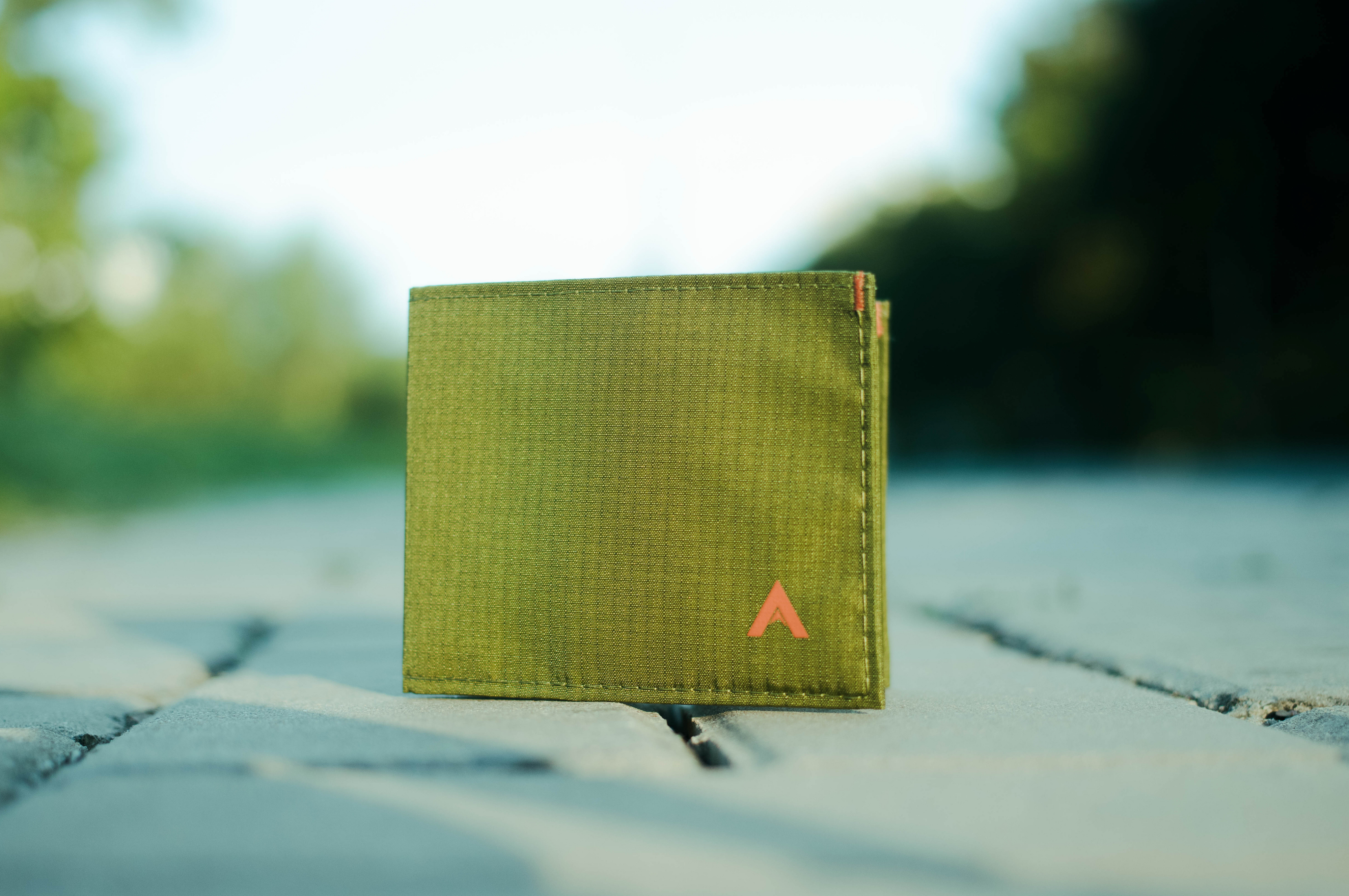 Allett Green Nylon Wallet on pavers with plants in background Affordable Holiday Gifts Under $50