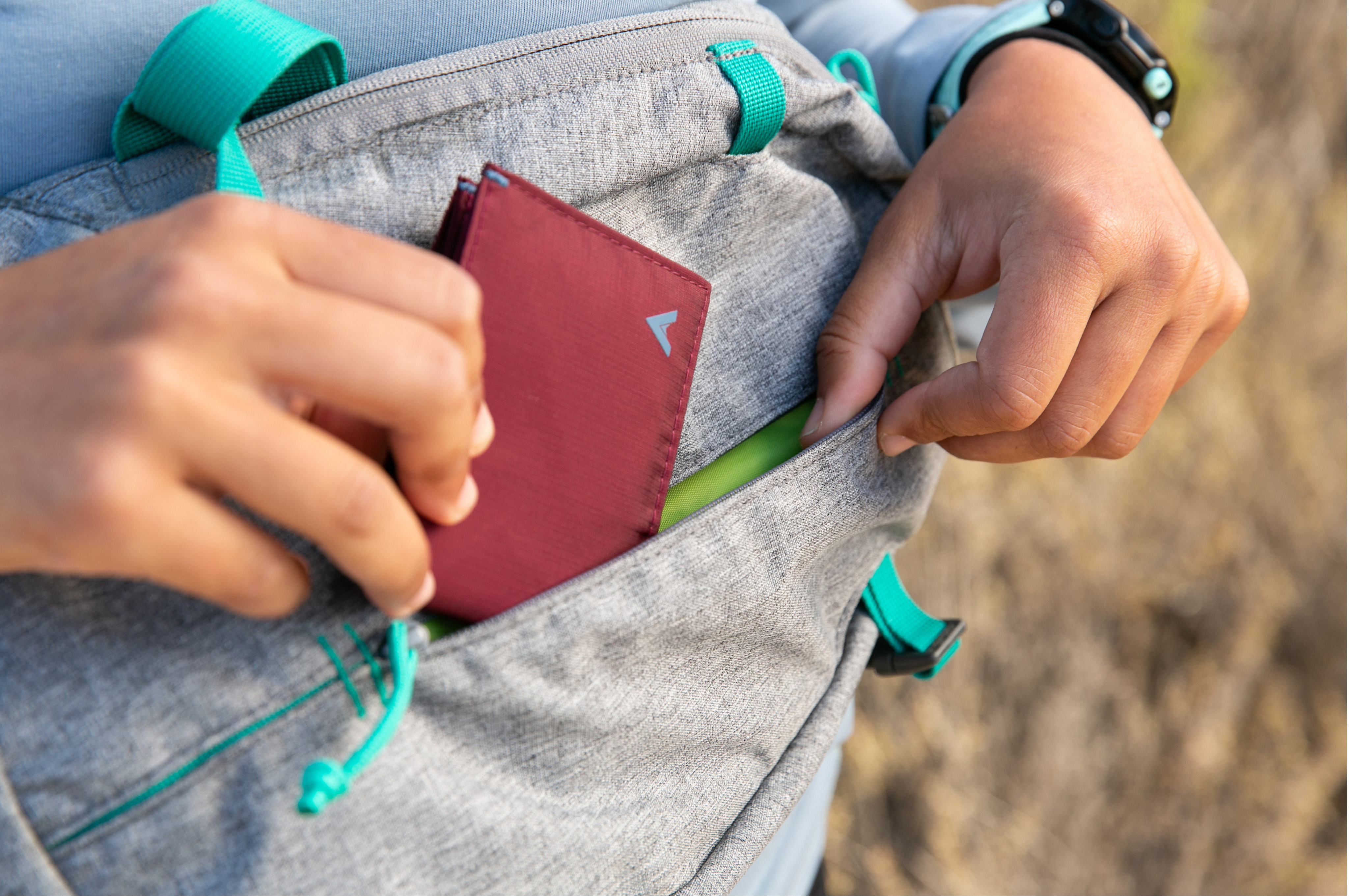 Stocking Stuffer Gifts by Allett Slim Wallet being put into a zipper pocket of a bag