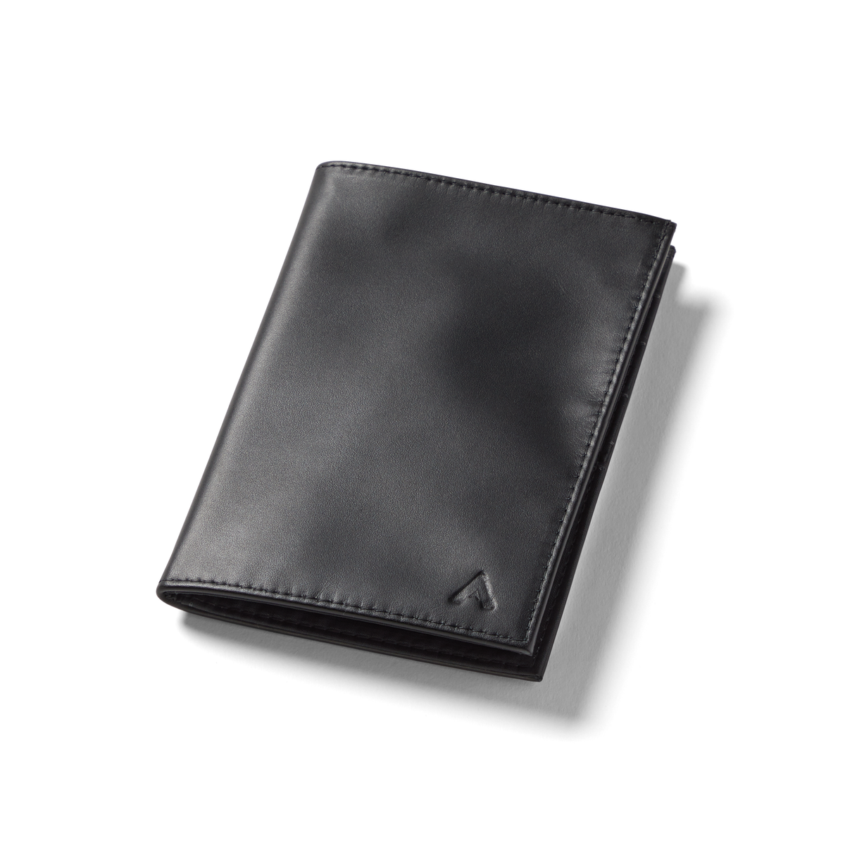 Allett's onyx black Nappa leather travel wallet, closed, and placed against a white background, showing the logo at the bottom right. Leather Travel Wallet by Allett with RFID protection - onyx-black