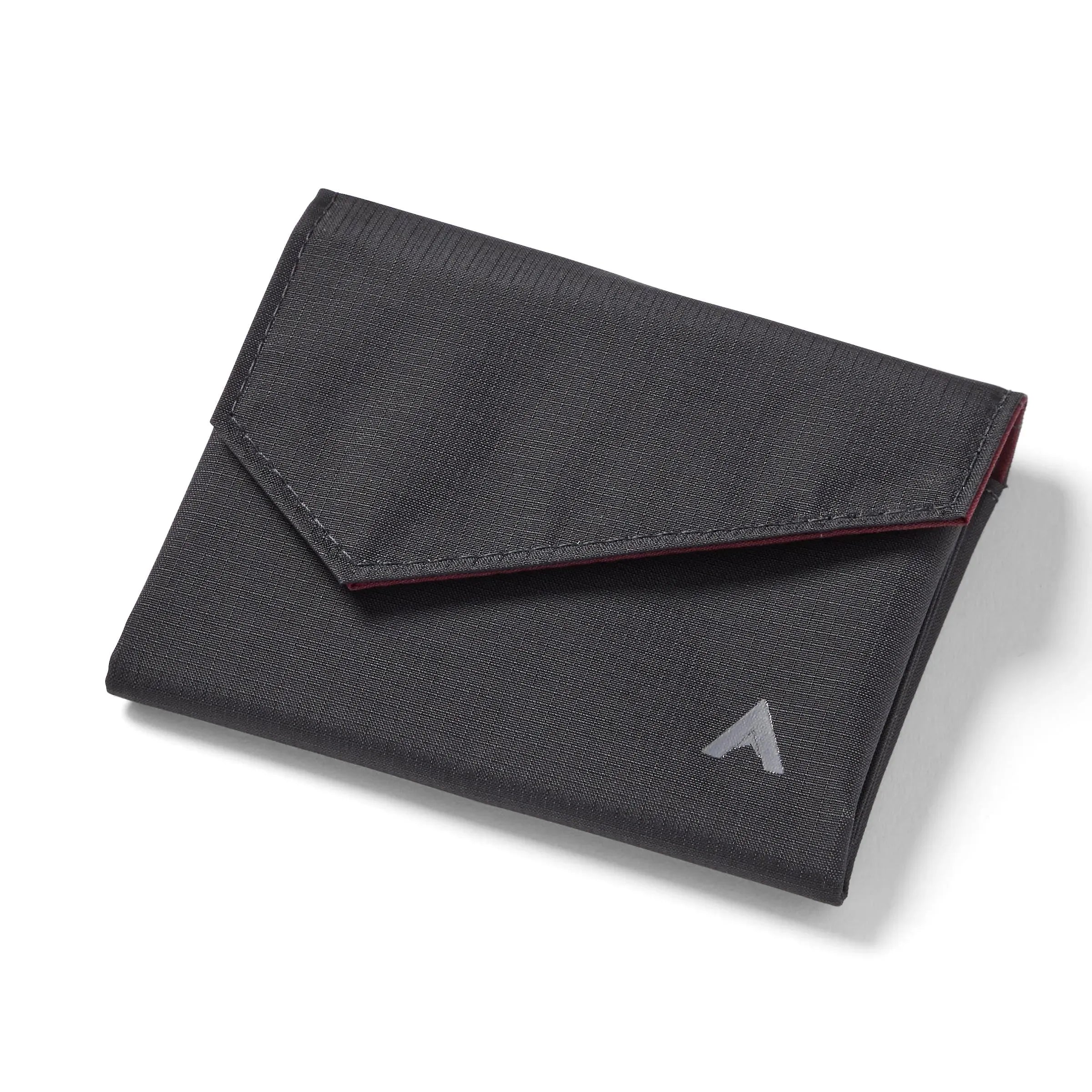 Allett's closed jet black nylon accordion wallet on a white backdrop, showcasing the logo on the bottom right and a front flap with an angled, slightly triangular shape. Allett Accordion Wallet in RFID Blocking Nylon  jet-black