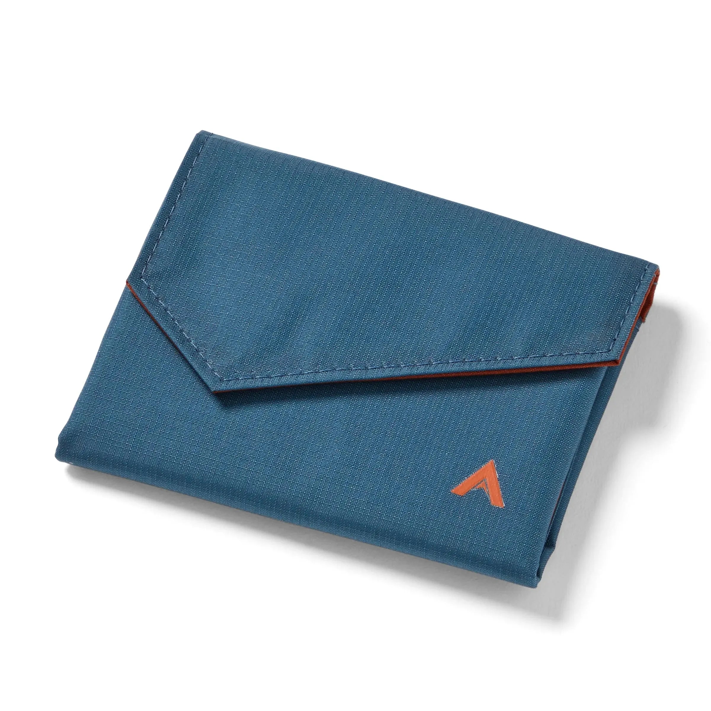 Closed indigo blue nylon accordion wallet from Allett, posed against white, with the logo at the bottom right and an angular, almost triangular front flap. Allett Accordion Wallet in RFID Blocking Nylon  indigo-blue