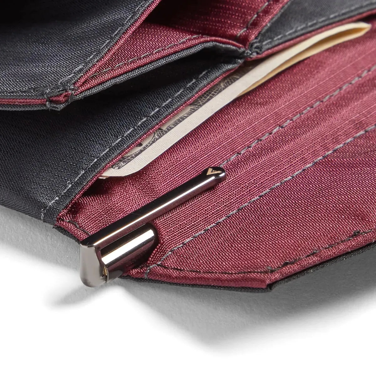Allett Micro Wallet Pen inserted into wallet, brass with a gunmetal finish
