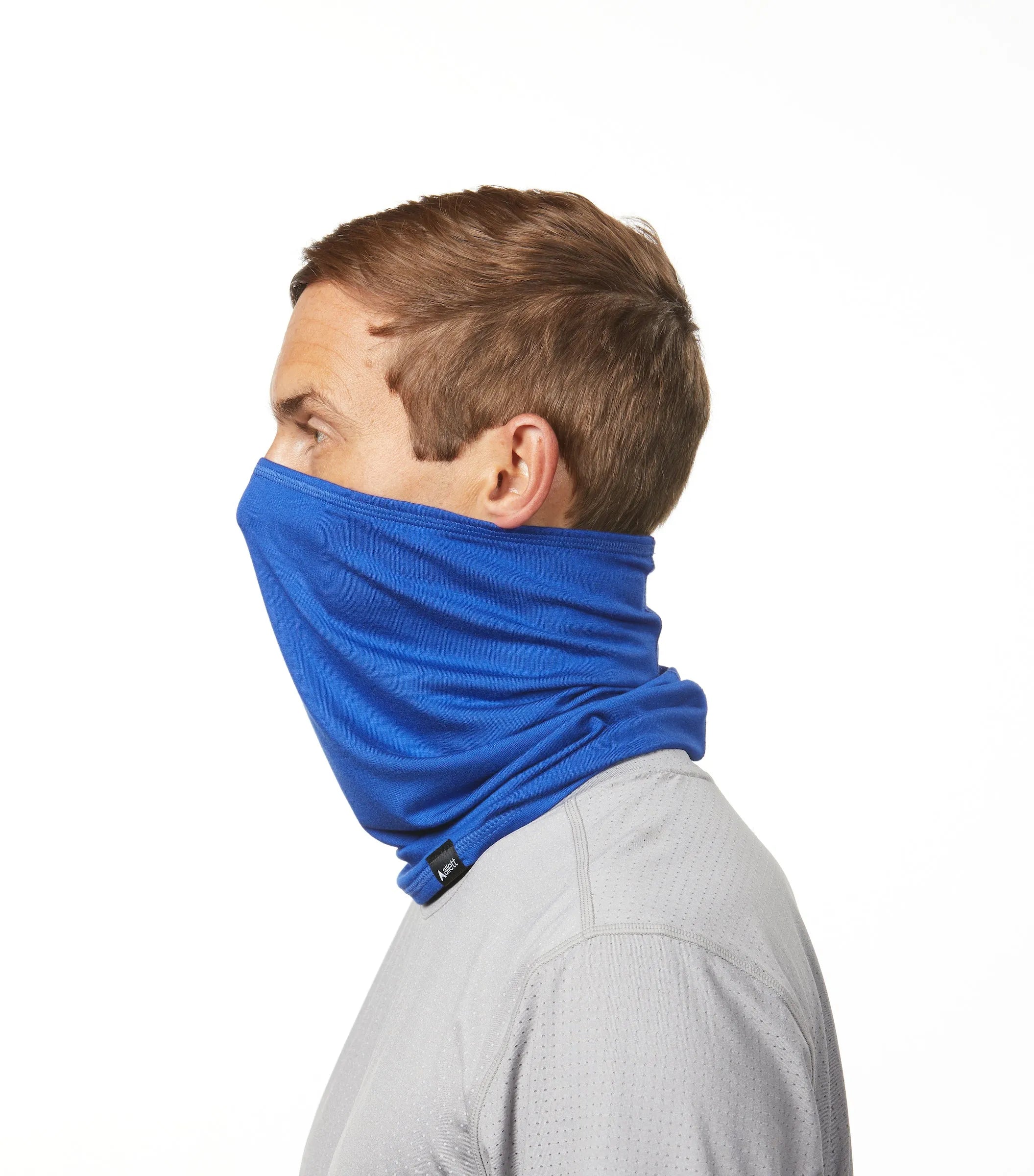 Man facing profile to the left wearing a cobalt blue neck gaiter face covering made from plants from Allett. cobalt-blue
