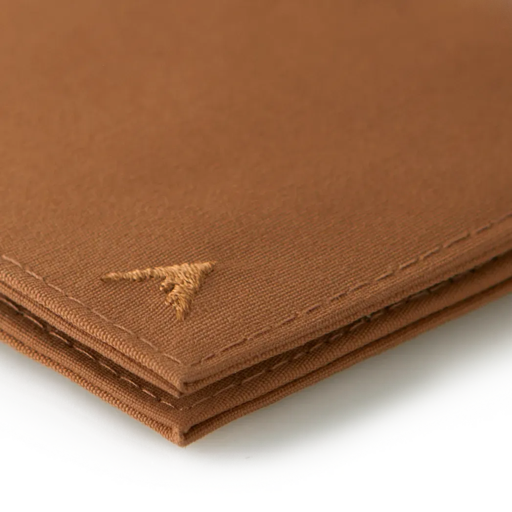 A detailed look at the sharp corner of the brown vegan nylon wallet, focusing on the Allett logo. Allett Lookout Nylon Wallet - brown