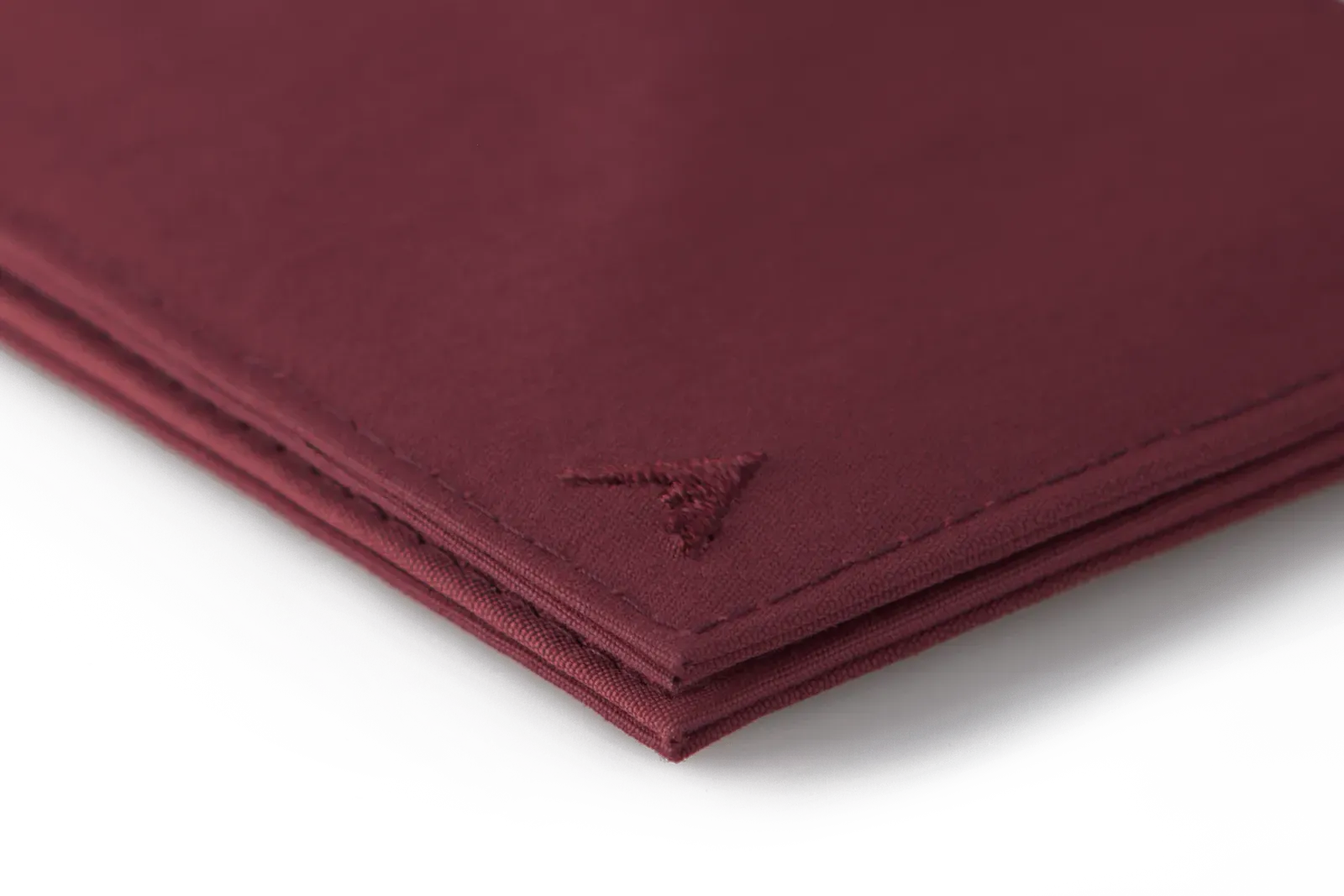 A close-up of the sleek corner of the vegan nylon wallet in oxblood, highlighting the distinctive Allett logo. Allett Lookout Nylon Wallet - oxblood