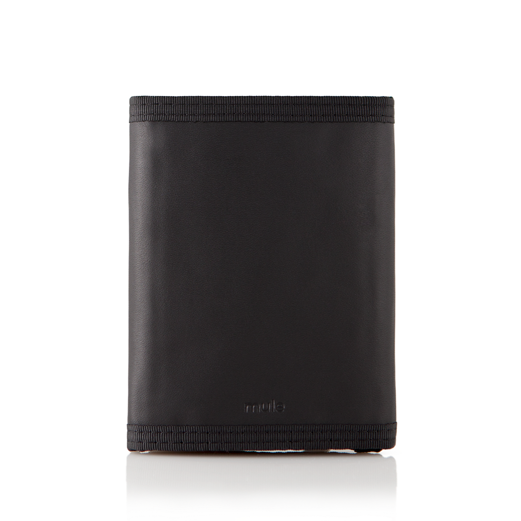 The back view of the black leather "Switchback" trifold wallet, closed, and placed against a white surface. Allett Switchback Leather Wallet - black